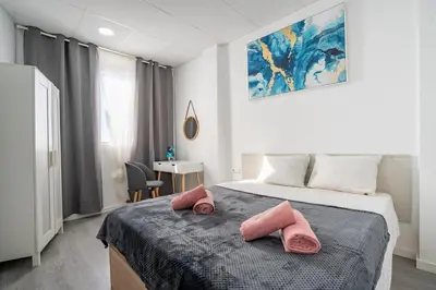 a bedroom with a bed with two pink pillows on it at Versus Apartment City Center in Valencia