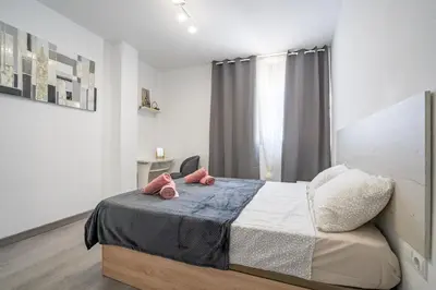 a bedroom with a bed with two pink pillows on it at Versus Apartment City Center in Valencia