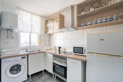a kitchen with white cabinets and a washer and dryer at Versus Apartment City Center in Valencia