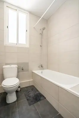 a white bathroom with a toilet and a bath tub at Versus Apartment City Center in Valencia