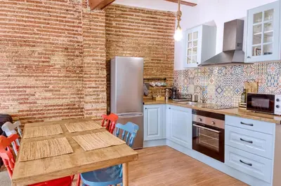 a kitchen with a wooden table and a brick wall at Beams & Bricks in Valencia