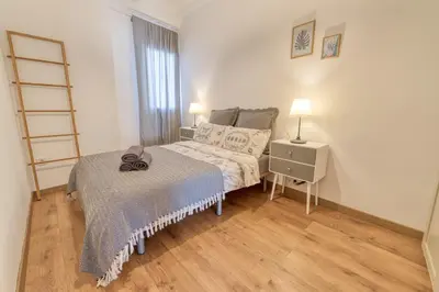 a small bedroom with a bed and a night stand at Beams & Bricks in Valencia