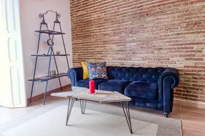 a blue couch in a living room with a brick wall at Beams & Bricks in Valencia