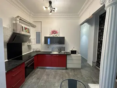 a large kitchen with red cabinets and a sink at 5 minuts Ruzzafa, perfect locatión 6PX & Wifi in Valencia