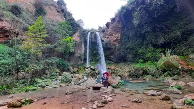 a group of people standing in a river with a waterfall at Anna, embrujo de la naturaleza in Anna