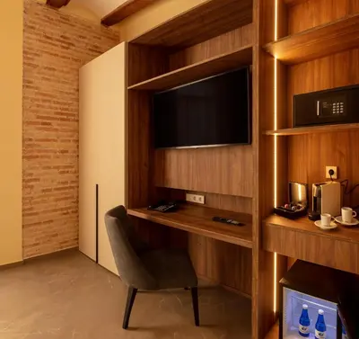 a room with a tv and a chair and a desk at SH Suite Palace in Valencia