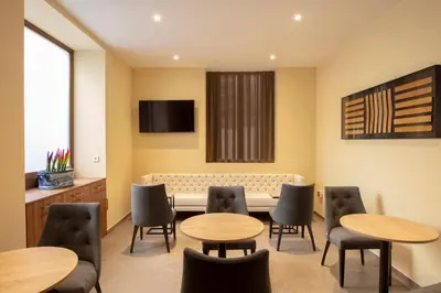 a waiting room with tables and chairs and a tv at SH Suite Palace in Valencia