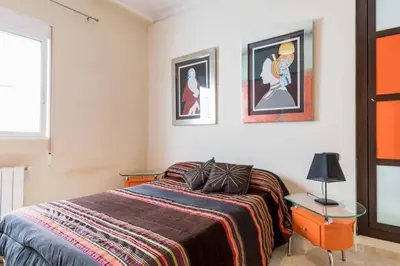 a bedroom with a bed with two tables and two pictures at PRECIOSO APARTAMENTO EN EL BARRIO DE RUZAFA in Valencia