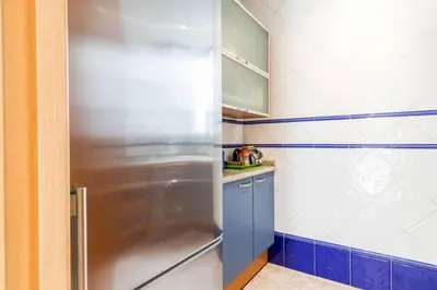 a kitchen with a stainless steel refrigerator and blue cabinets at PRECIOSO APARTAMENTO EN EL BARRIO DE RUZAFA in Valencia