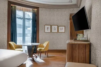 a room with a bed and a tv and a table at Palacio Santa Clara, Autograph Collection in Valencia