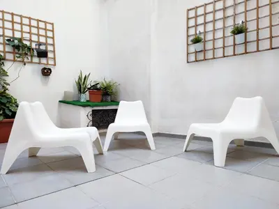 three white chairs sitting next to a table at Flats Friends Tetuan in Valencia