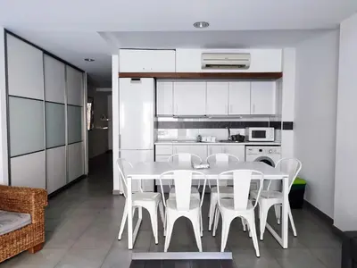 a kitchen and dining room with a white table and chairs at Flats Friends Tetuan in Valencia