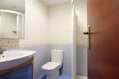 a bathroom with a white toilet and a sink at Global Vacacional, Adosado en la playa con piscina in Sagunto