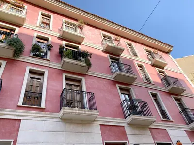 a pink building with balconies and plants on it at Valencia Centro. Wifi/AACC Jacuzzi in Valencia