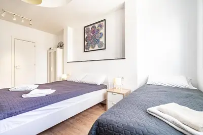 a bedroom with two beds and a picture on the wall at Jardín Botánico Rooms in Valencia