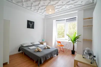 a bedroom with a bed and a desk and a window at Jardín Botánico Rooms in Valencia