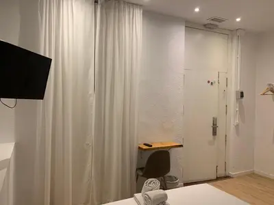a bedroom with a desk and a white curtain at Star Home in Valencia