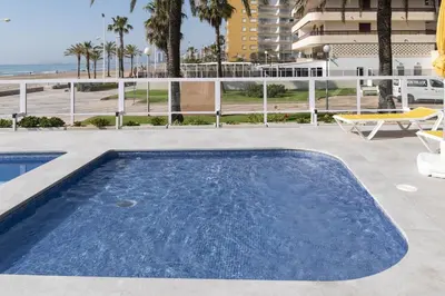 a swimming pool on a patio with a view of the ocean at Florazar 3, 8º-B in Cullera