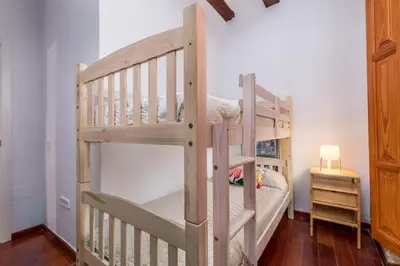 a wooden bunk bed with a ladder in a room at Travel Habitat Plaza de la Virgen in Valencia