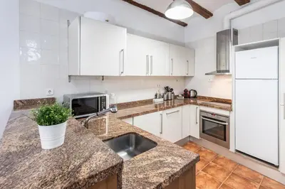 a kitchen with white cabinets and a sink at Travel Habitat Plaza de la Virgen in Valencia