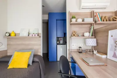 a living room with a couch and a desk with a laptop at Residencia Universitaria Resa La Concepción in Valencia