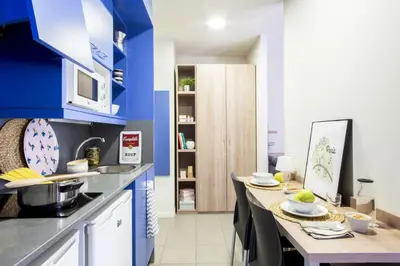 a kitchen with blue walls and a table with dishes on it at Residencia Universitaria Resa La Concepción in Valencia