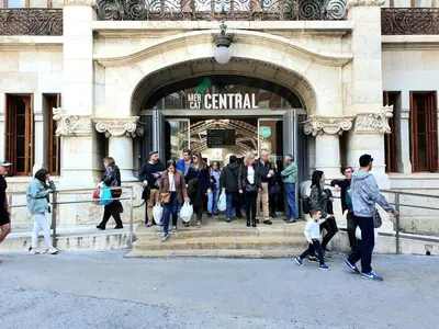 a group of people walking outside of a building at Mercat Suites in Valencia