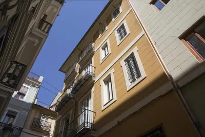 a yellow building with white windows and balconies at Mercat Suites in Valencia