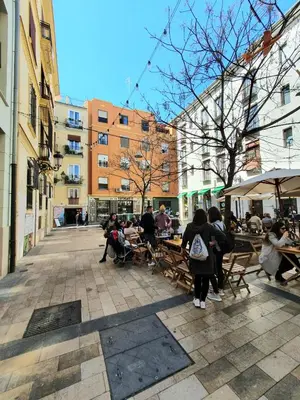 a group of people sitting at tables in a courtyard at Mercat Suites in Valencia