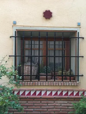a window with a iron fence and plants on it at La casita de la dormilona in Algimia de Almonacid