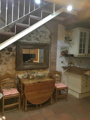 a kitchen with a table and chairs and a staircase at La casita de la dormilona in Algimia de Almonacid