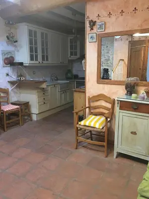 a kitchen with white cabinets and a table and chairs at La casita de la dormilona in Algimia de Almonacid