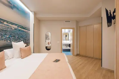 a bedroom with a large bed with a large painting on the wall at Palau Suites & Apartments in Valencia