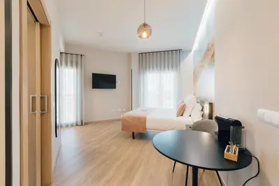 a hotel room with a bed and a table at Palau Suites & Apartments in Valencia