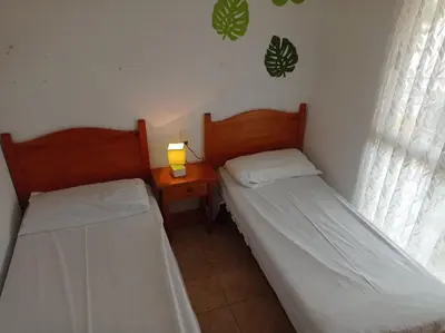 two beds in a room with a lamp on a table at Bitacora II solo Familias Serviplaya in Casas Las Basas