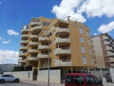 a yellow building with cars parked in front of it at Bitacora II solo Familias Serviplaya in Casas Las Basas