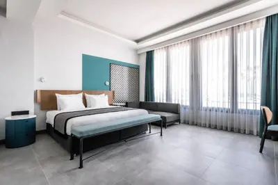 a bedroom with a bed and a couch and windows at PAMPHYLIA HOTEL in Valencia