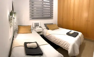 a room with two twin beds and a desk at Natura Apartments in Chelva