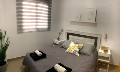 a bedroom with a bed with two pillows and a window at Natura Apartments in Chelva
