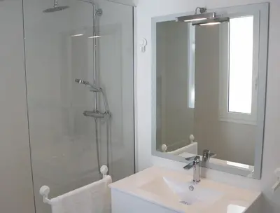 a bathroom with a sink and a shower with a mirror at Balaustrada Apartments in Burjasot