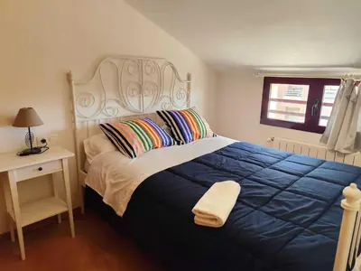 a bedroom with a large bed with a blue blanket at Caudiel entre Sierras in Caudiel
