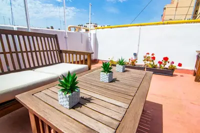 a wooden table on a balcony with a couch and plants at Kasa Katia Guest House in Valencia