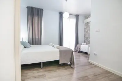 a white bedroom with a bed and a window at Kasa Katia Guest House in Valencia