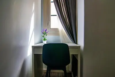 a desk with a green chair in front of a window at Kasa Katia Guest House in Valencia