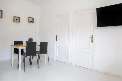 a dining room with a table and chairs and a television at Kasa Katia Guest House in Valencia