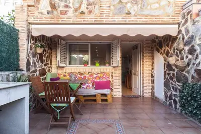 a patio with a table and chairs and a window at Villa del Mar . in Puebla de Farnals