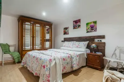 a bedroom with a large bed and a chair at Villa del Mar . in Puebla de Farnals