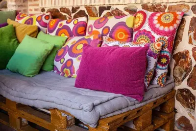 a bench with colorful pillows on it at Villa del Mar . in Puebla de Farnals