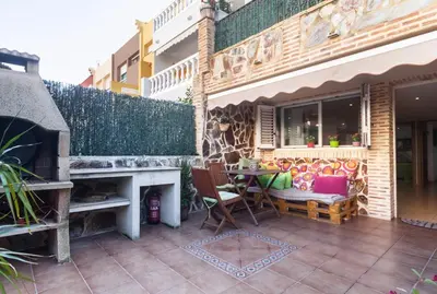 a patio with a fireplace and a table and chairs at Villa del Mar . in Puebla de Farnals