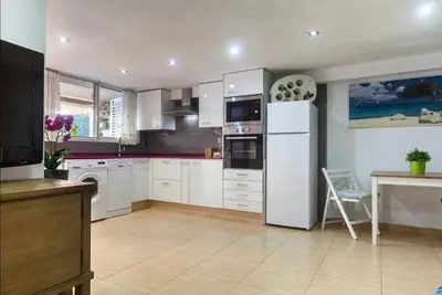 a kitchen with white cabinets and a white refrigerator at Villa del Mar . in Puebla de Farnals